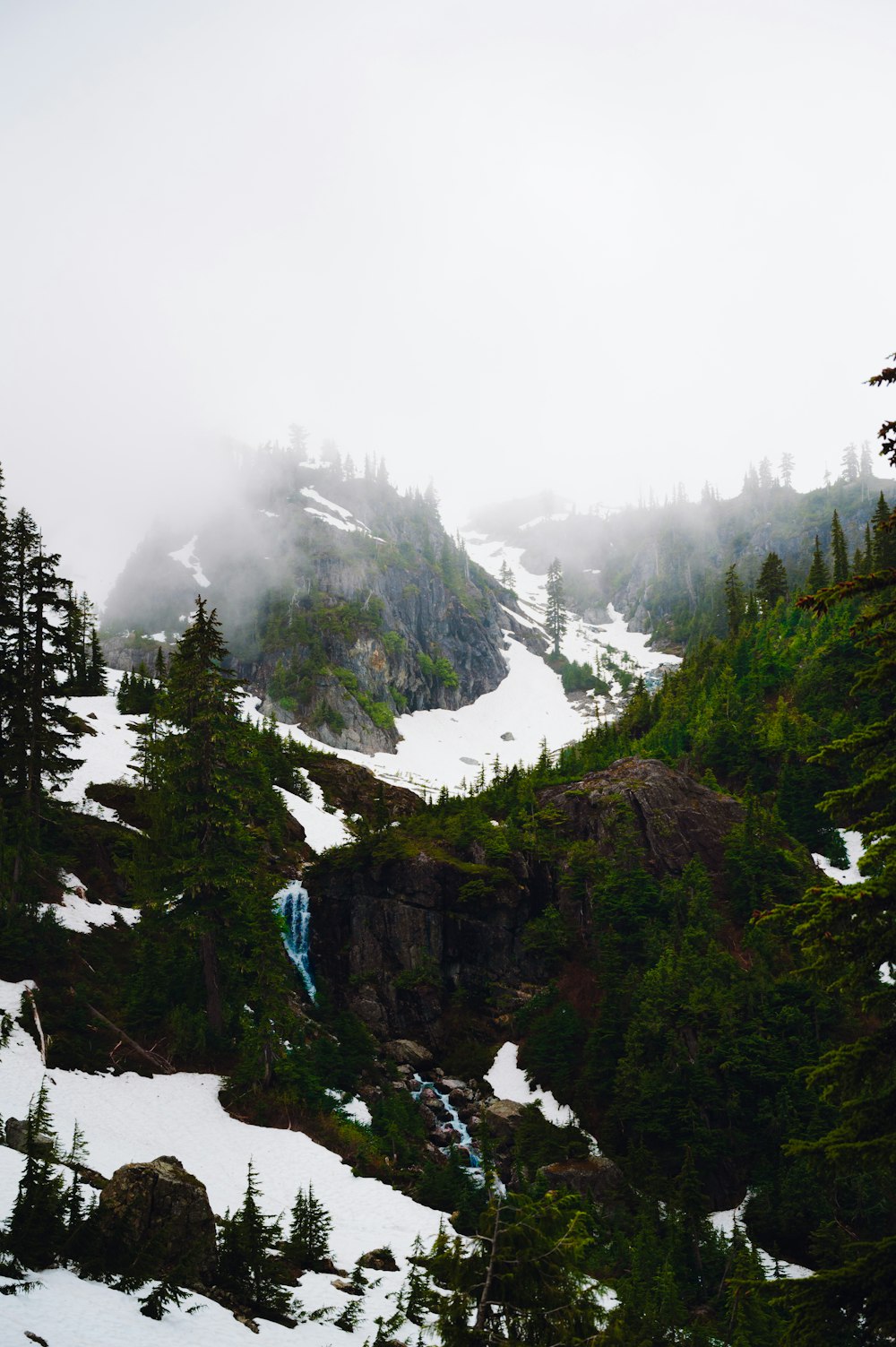 a snowy mountain with a waterfall in the middle of it