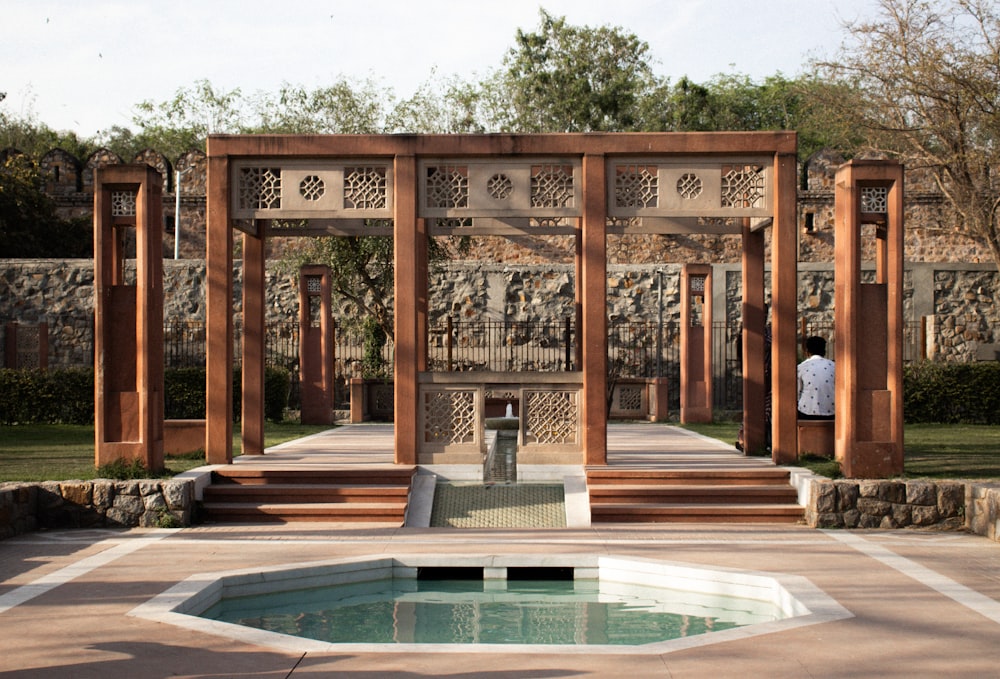 a man standing in front of a fountain in a park