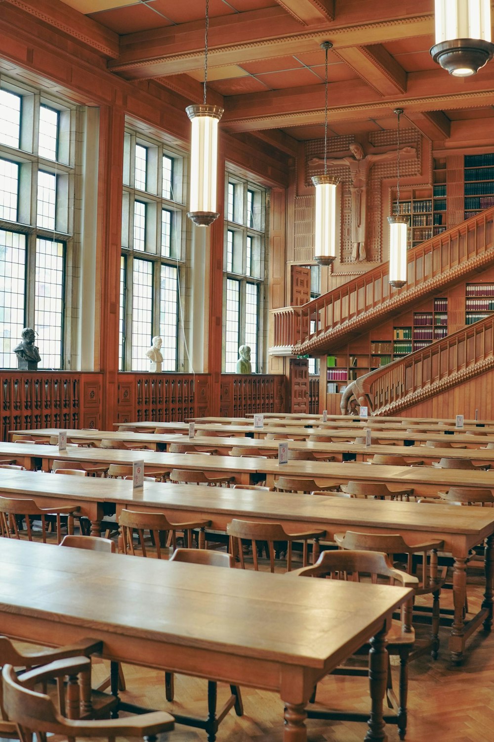 a library with tables and chairs and a staircase