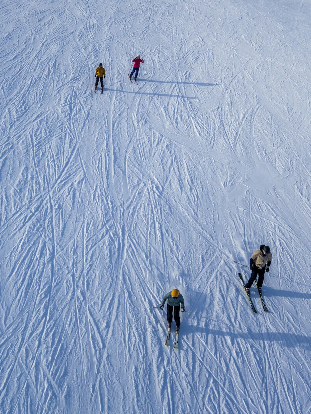 a group of people riding skis down a snow covered slope