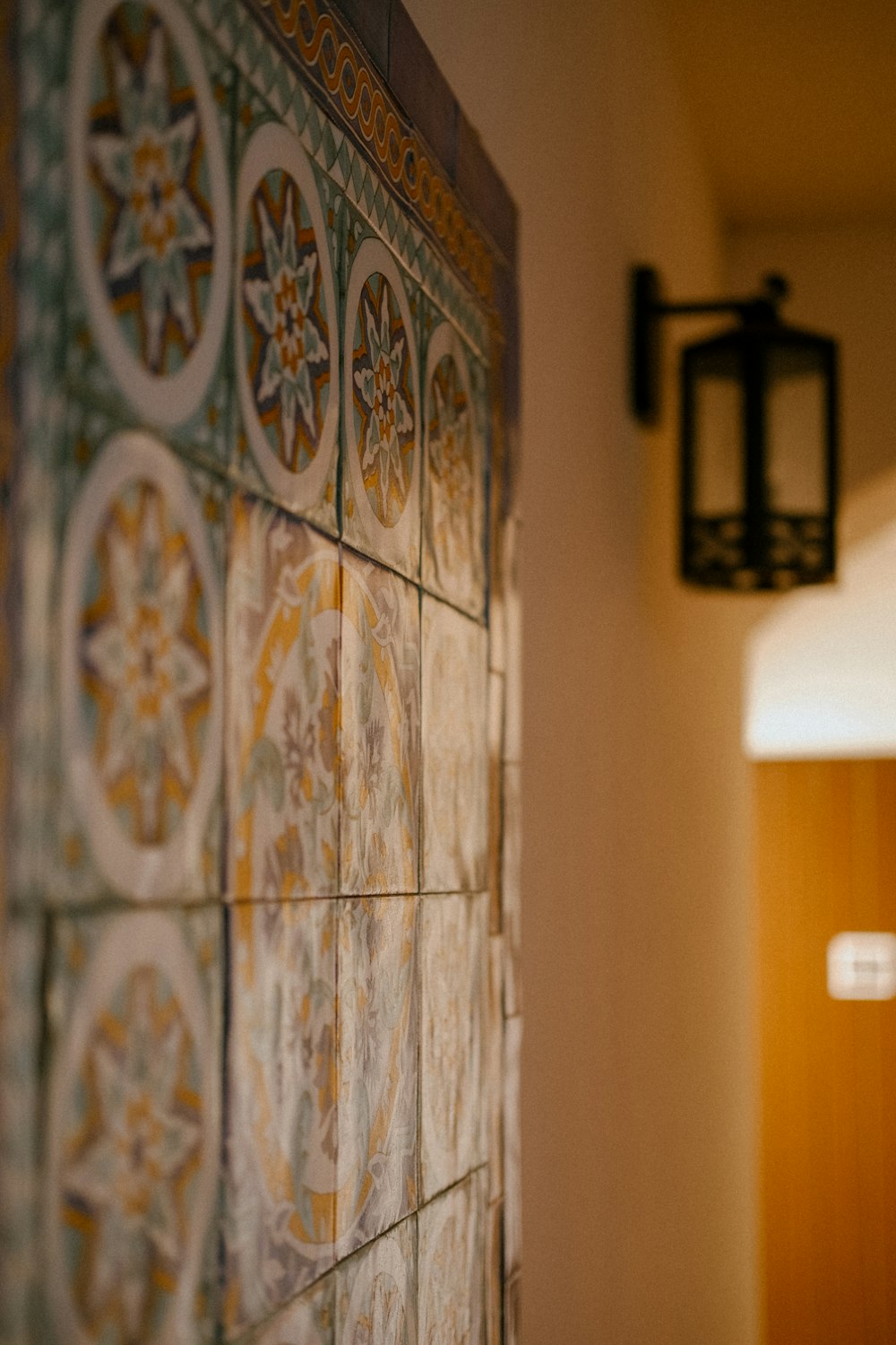 a close up of a tile wall with a light in the background
