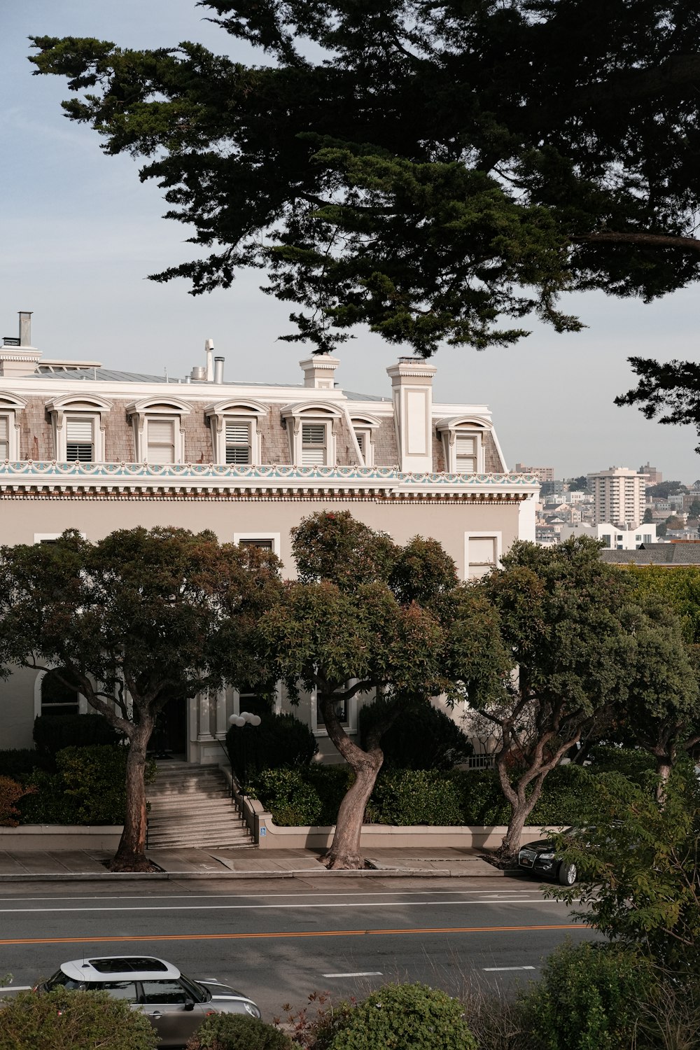 a large white building with a lot of trees in front of it