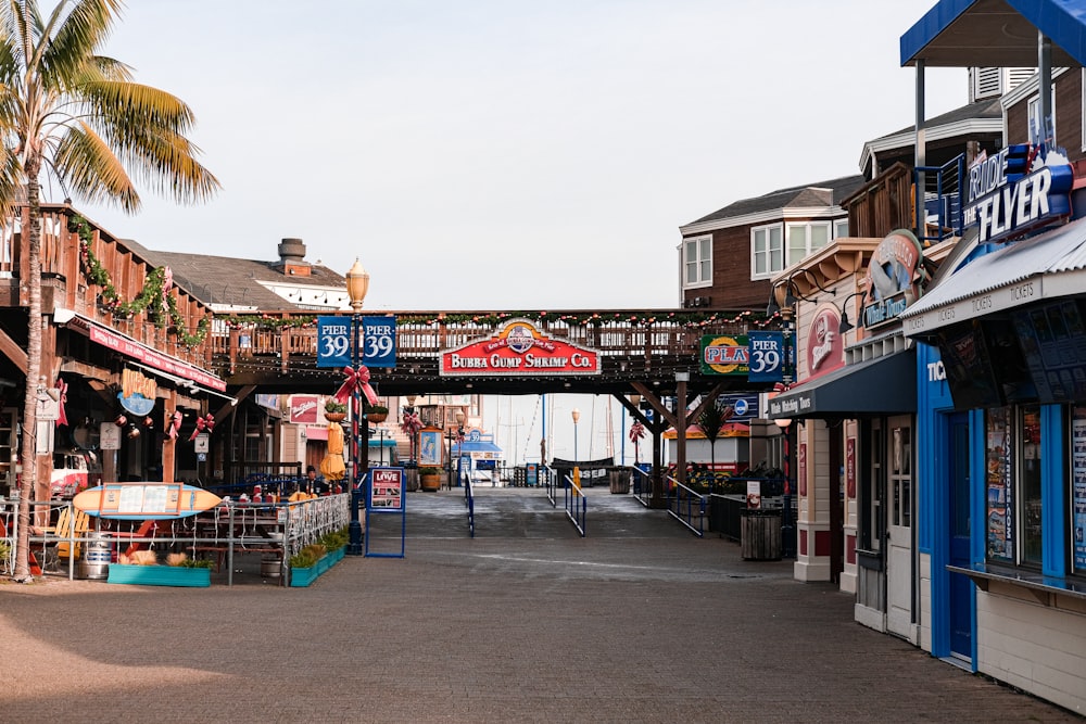 a street lined with shops and stores next to a palm tree