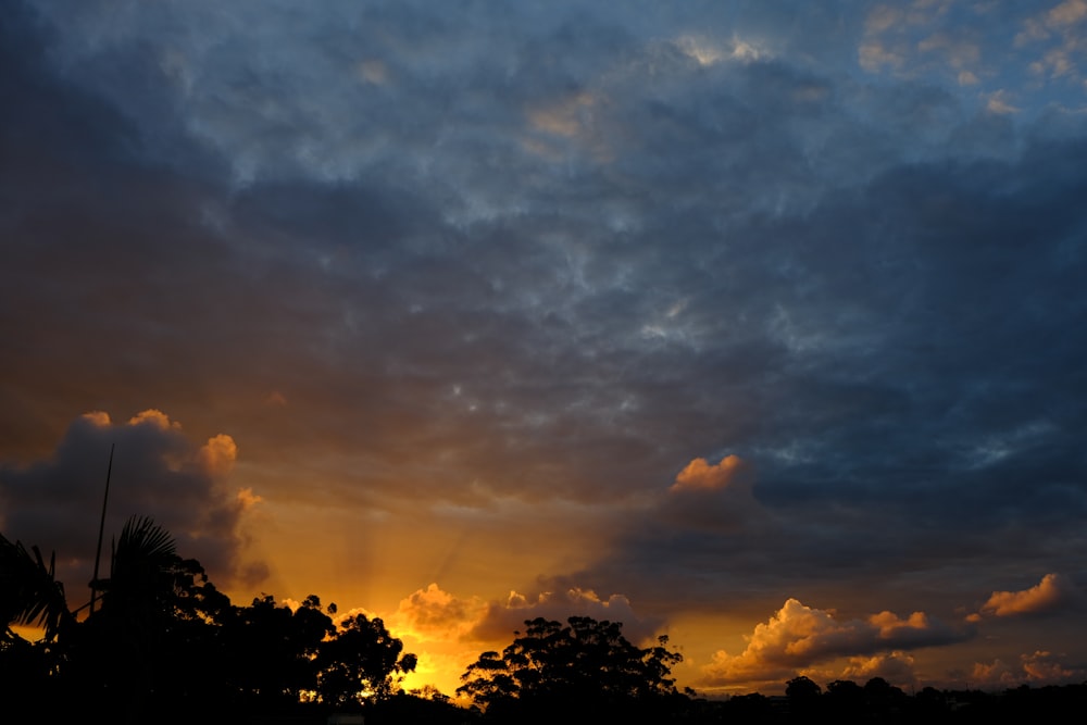 the sun is setting behind the clouds in the sky