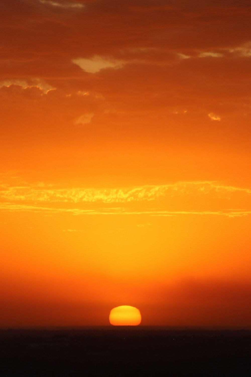 the sun is setting over the horizon of a large body of water