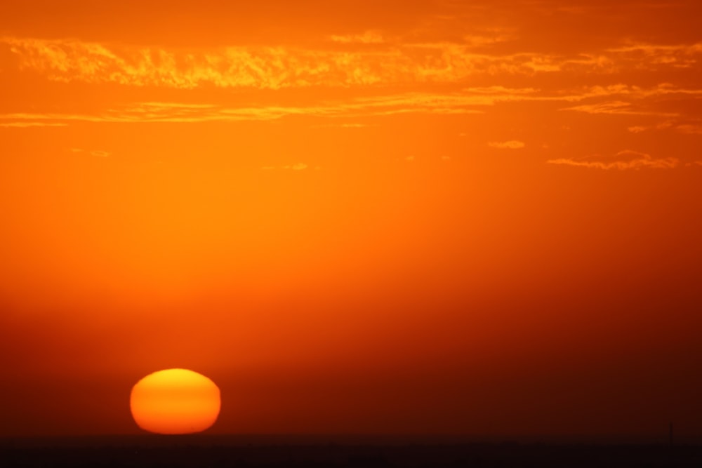 the sun is setting over the horizon of the ocean