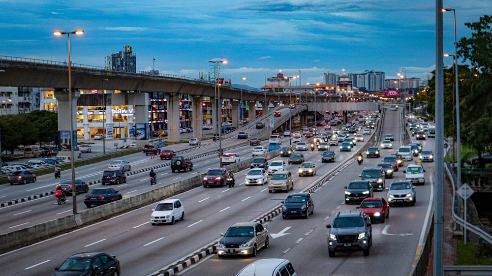 a highway filled with lots of traffic next to tall buildings