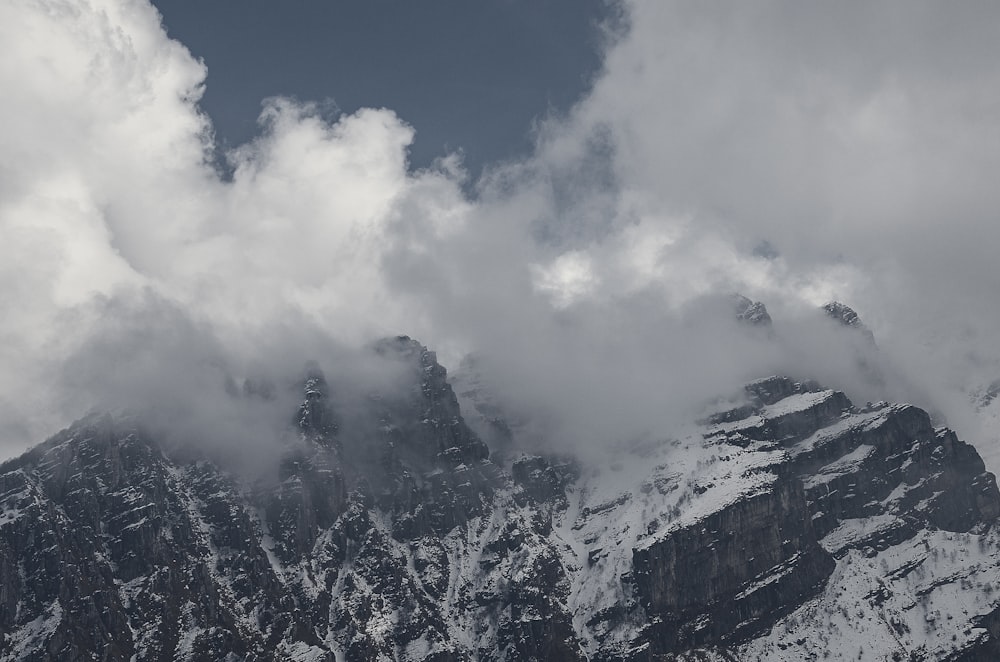 una montaña cubierta de nieve y nubes bajo un cielo azul