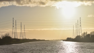 a body of water with power lines in the background