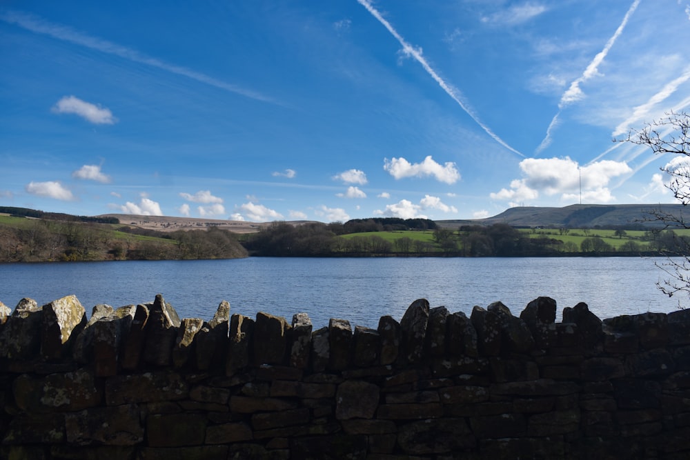 a stone wall next to a body of water