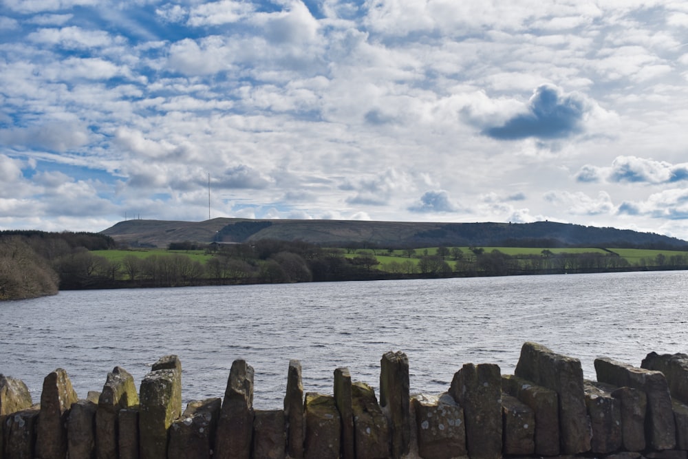 a large body of water surrounded by a lush green hillside