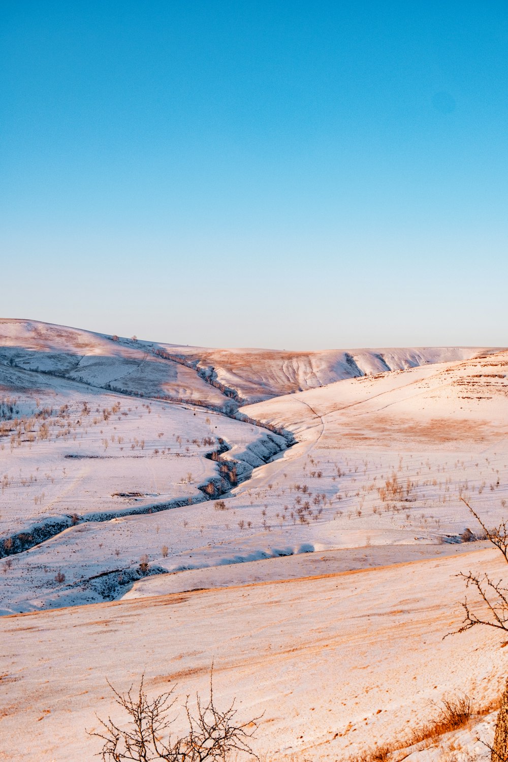 a view of a snowy landscape from a hill