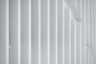 a man in a suit and tie standing in front of a white wall