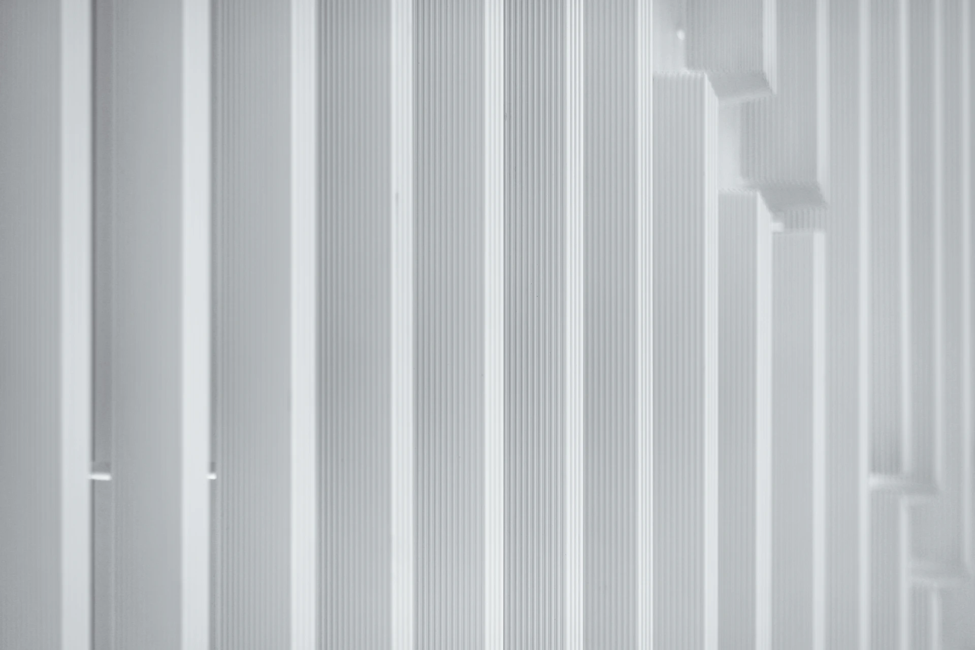 a man in a suit and tie standing in front of a white wall