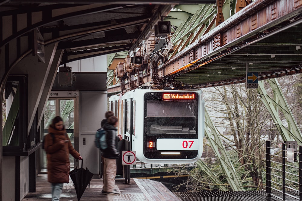 Un par de personas que están de pie junto a un tren