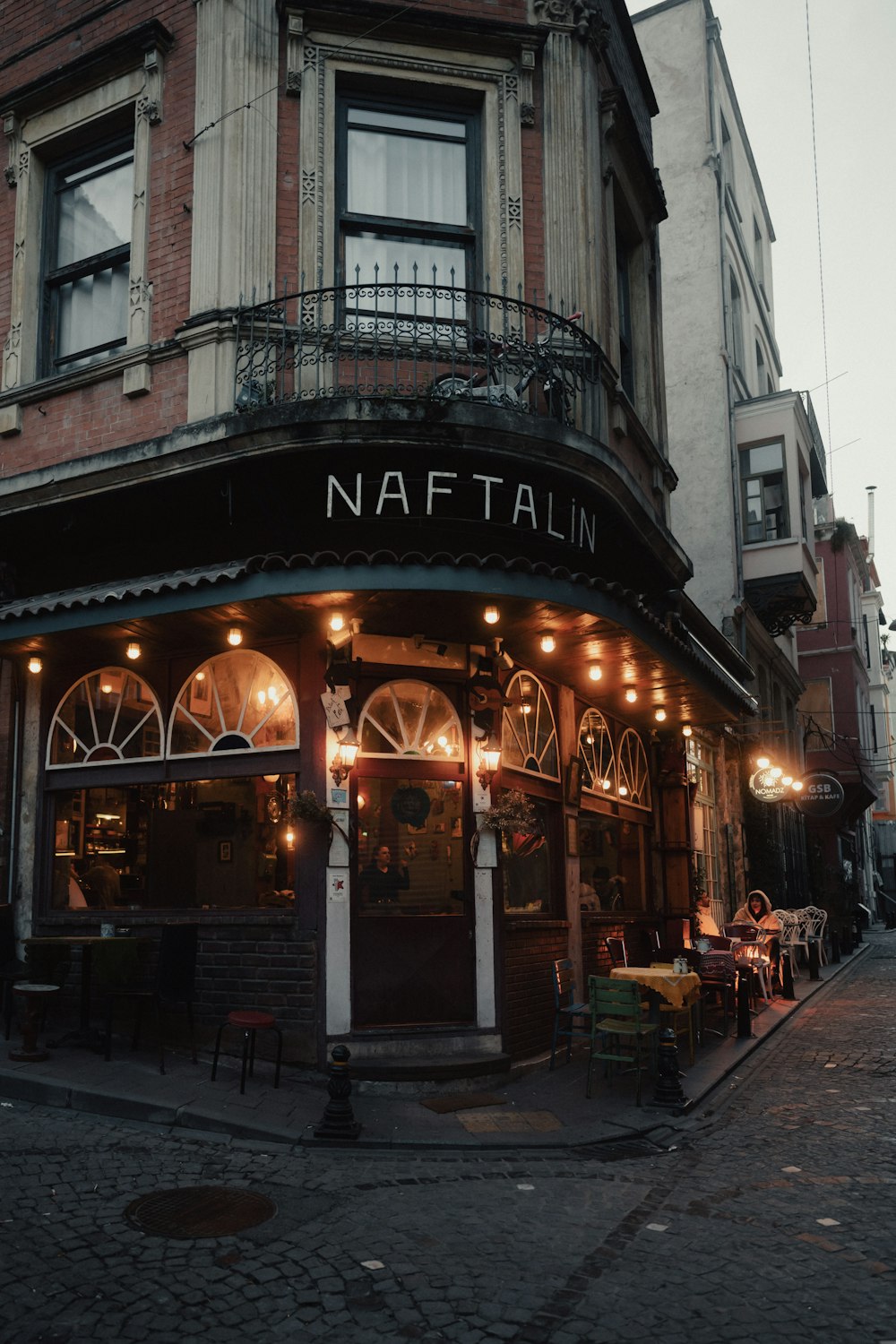 a street corner with a restaurant called naftalim