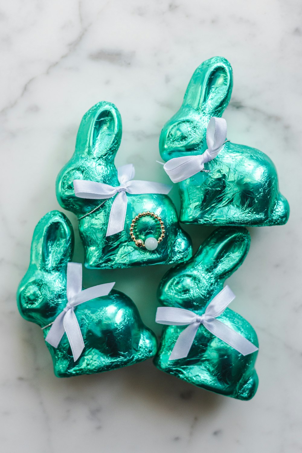 a group of green foiled rabbits on a marble surface