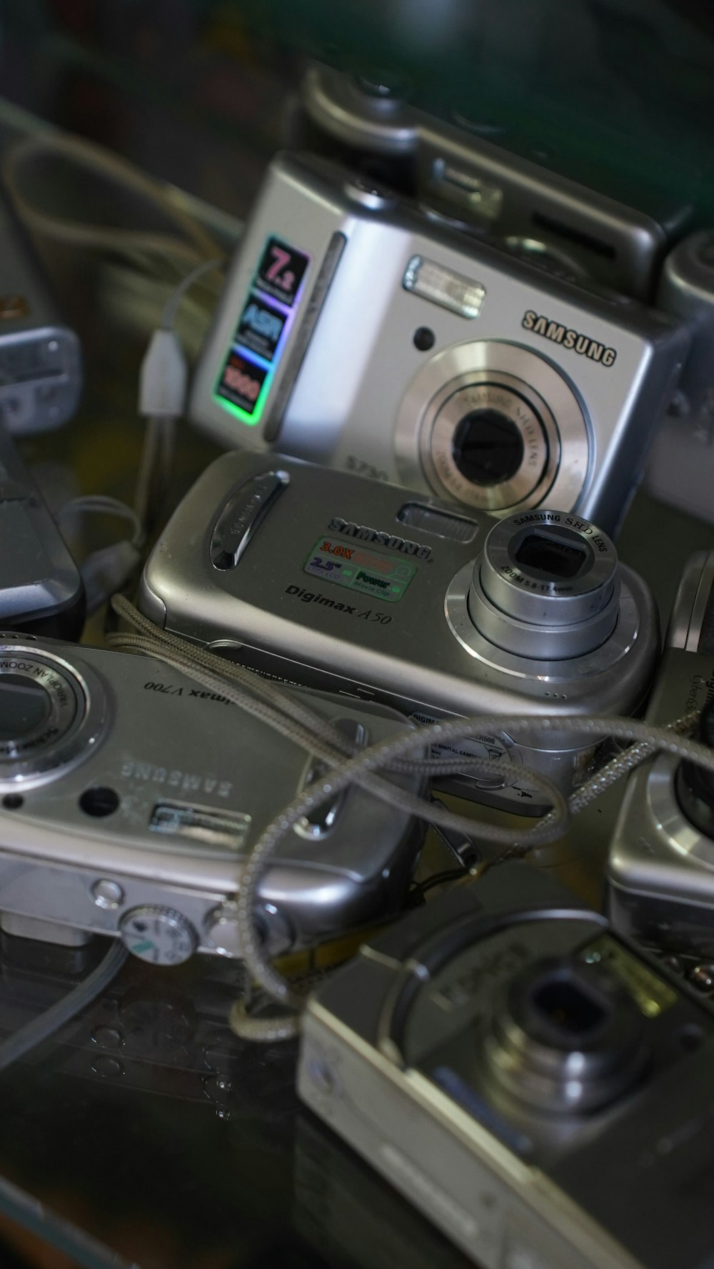 a bunch of cameras sitting on top of a glass table