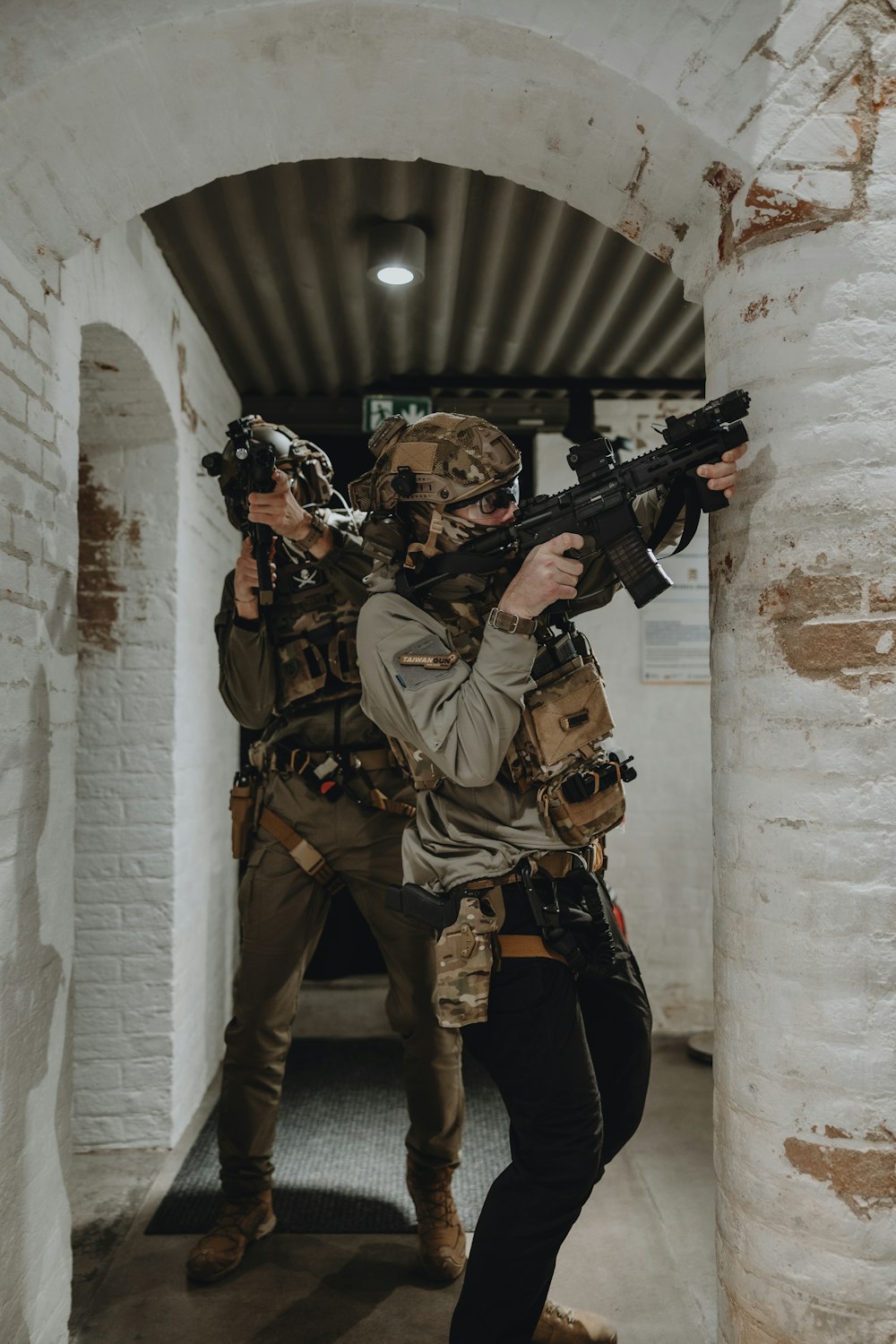 a man holding a gun while standing next to another man