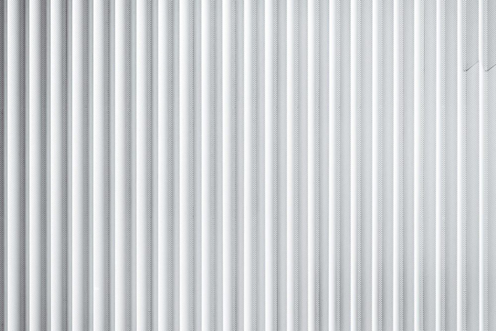 a close up of a white wall with vertical lines