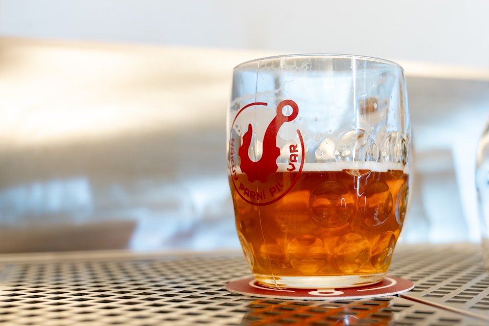 a glass of beer sitting on top of a table