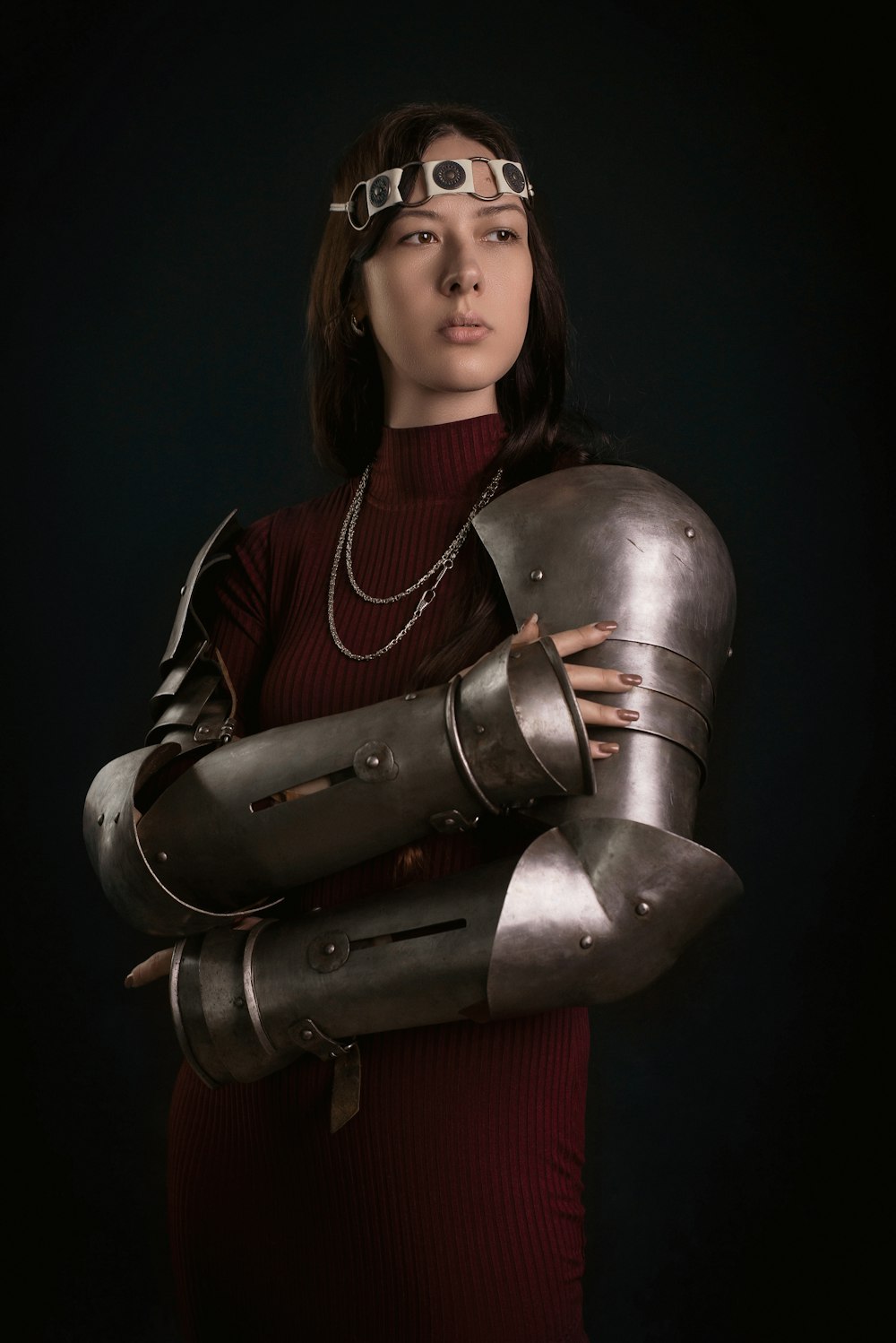 a woman in a red dress holding a metal armor