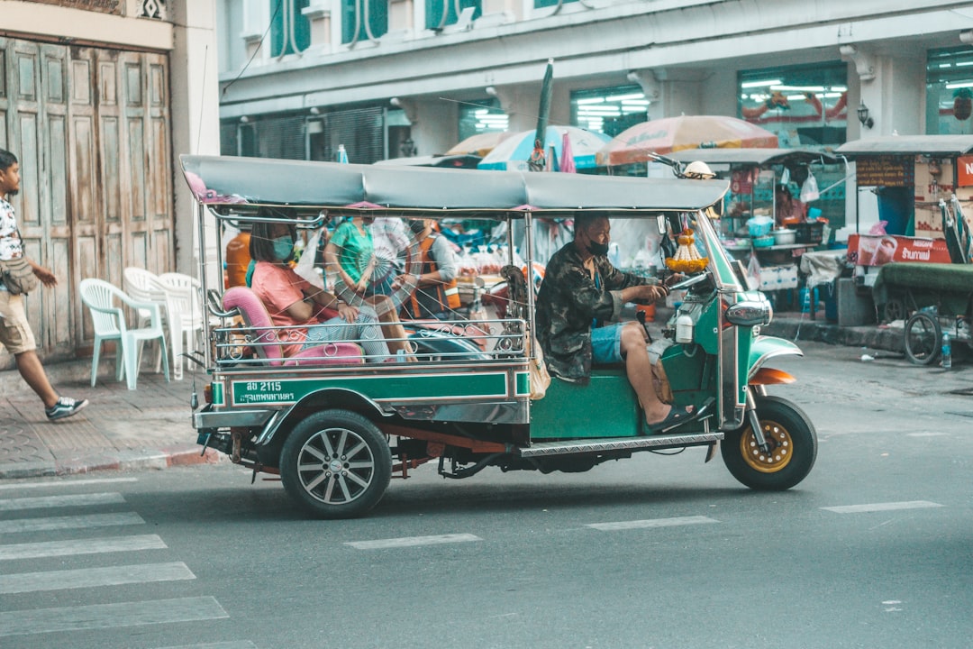 a tuk tuk driving down a city street,