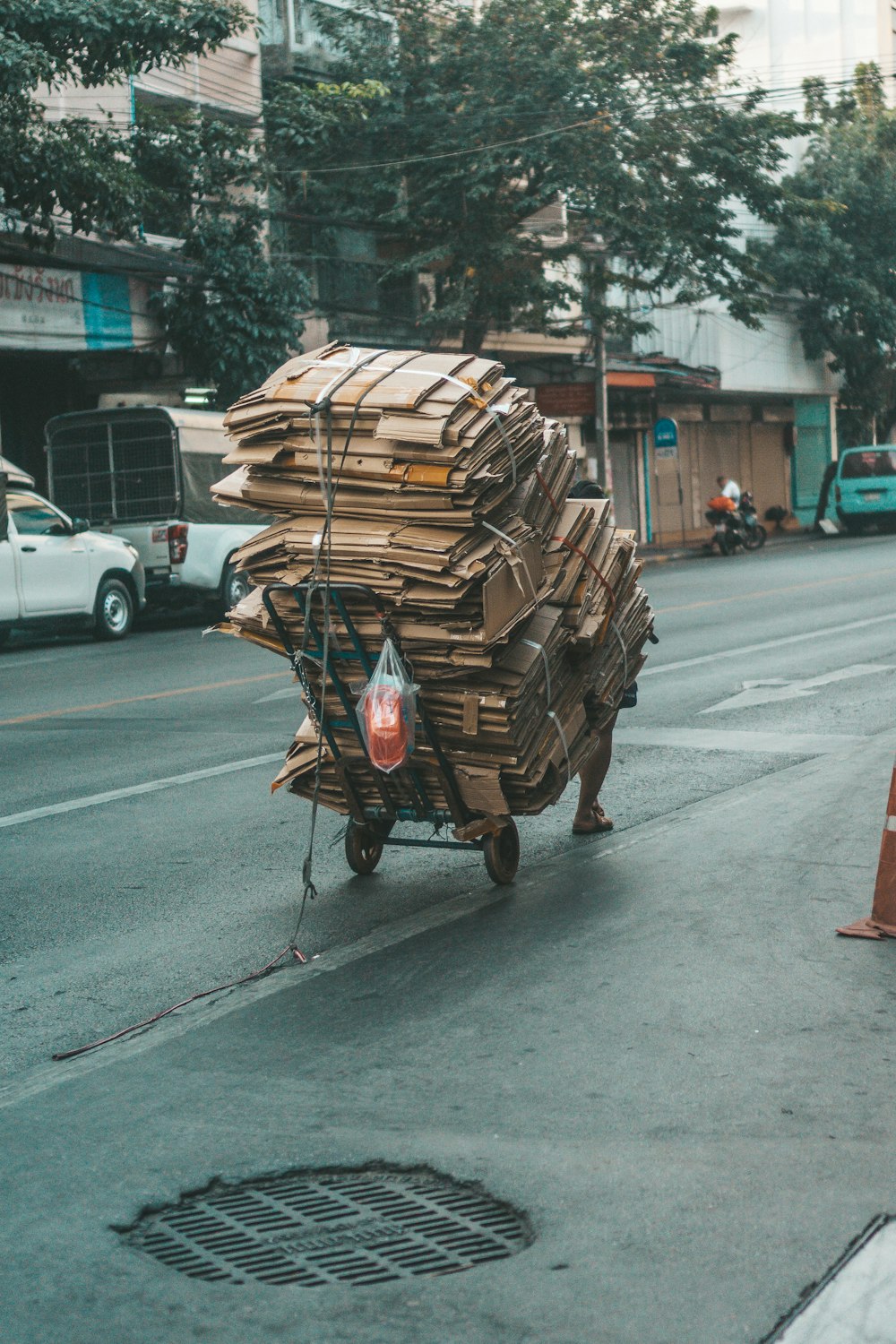 a man pushing a cart full of wood down a street