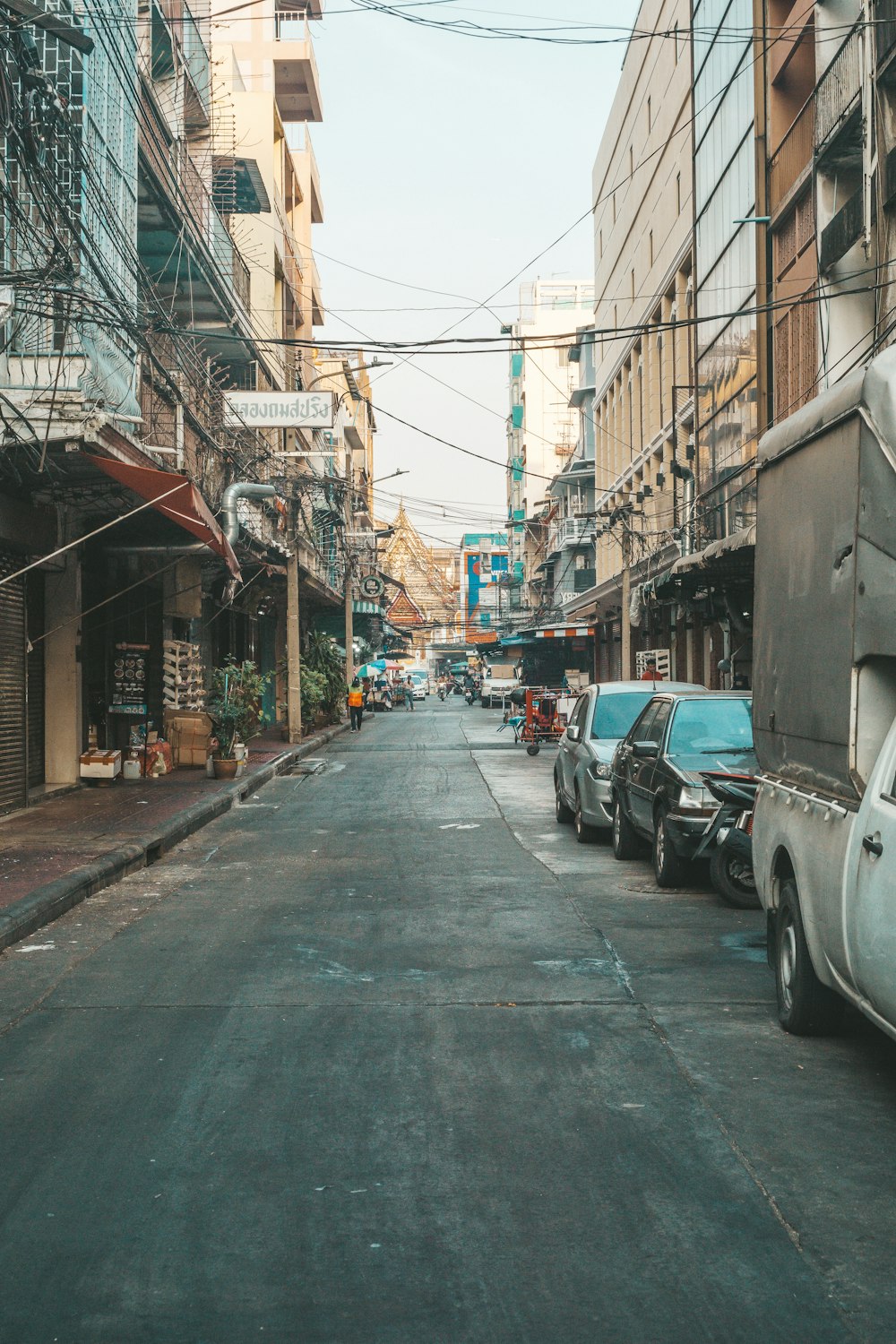 a city street lined with parked cars and tall buildings