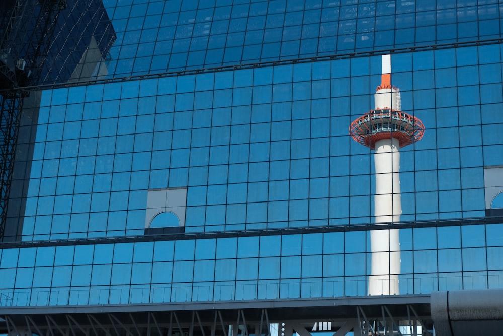 um reflexo de uma torre em um edifício de vidro
