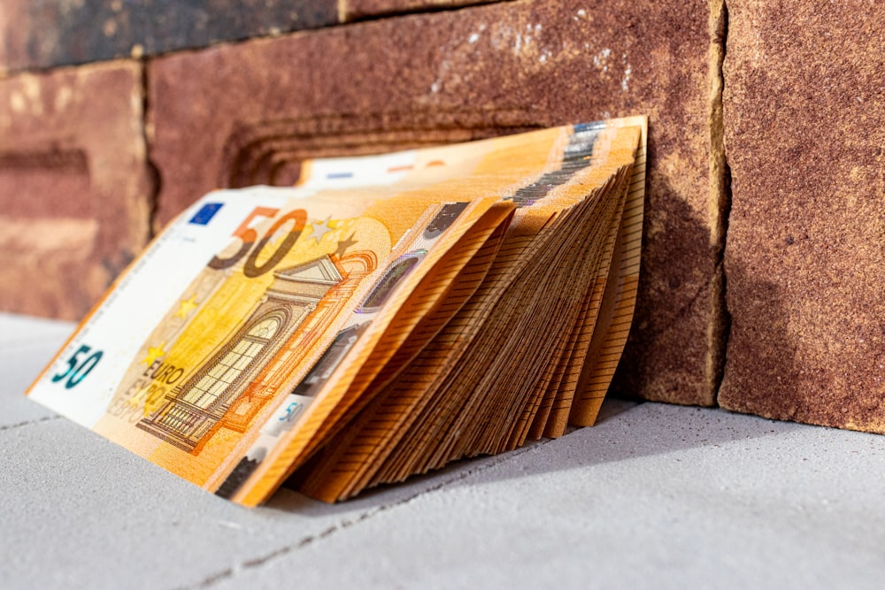 a stack of money sitting on top of a sidewalk