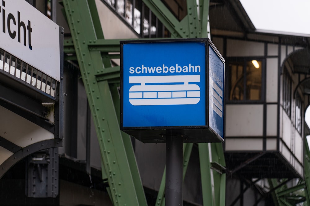 a blue and white sign hanging from the side of a building