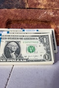 a stack of one dollar bills sitting on top of a table