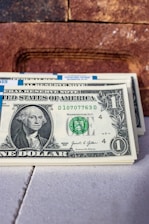 a stack of one dollar bills sitting on top of a table
