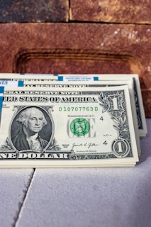 a stack of one dollar bills sitting on top of a table