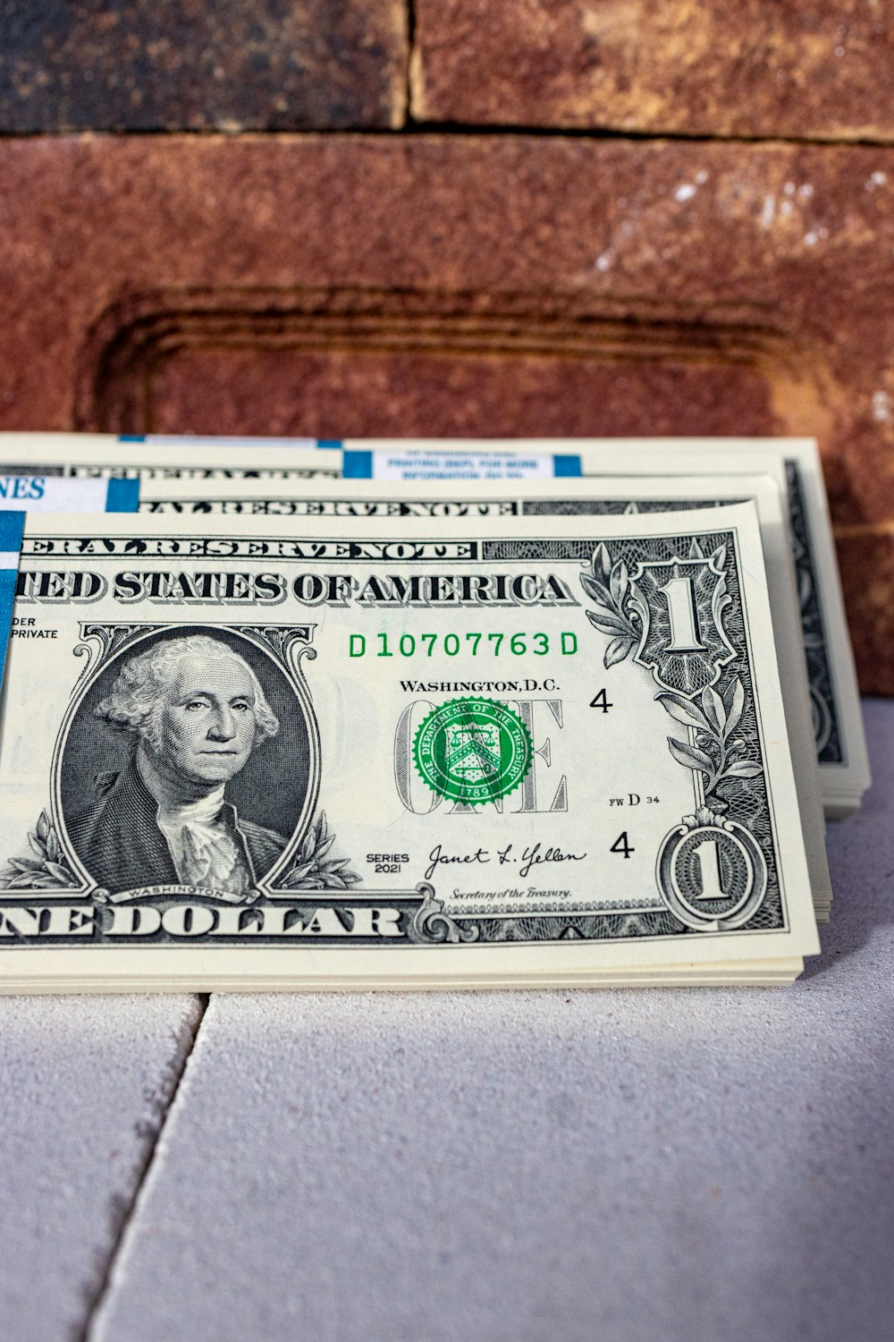 a stack of one dollar bills sitting on top of a table