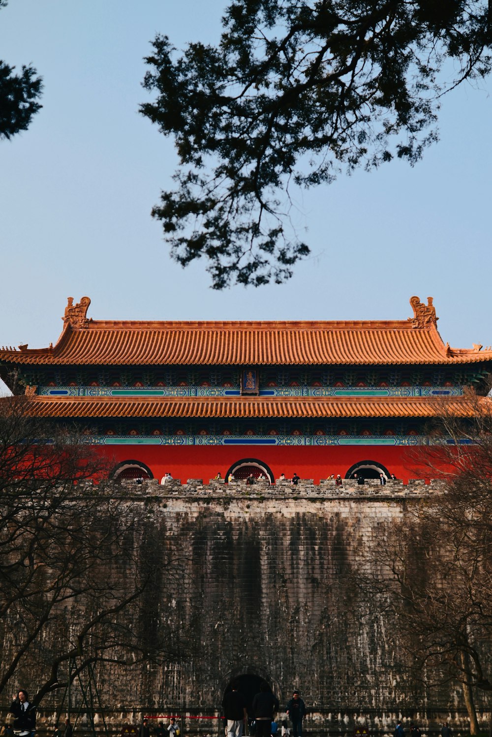 a tall building with a red roof next to trees