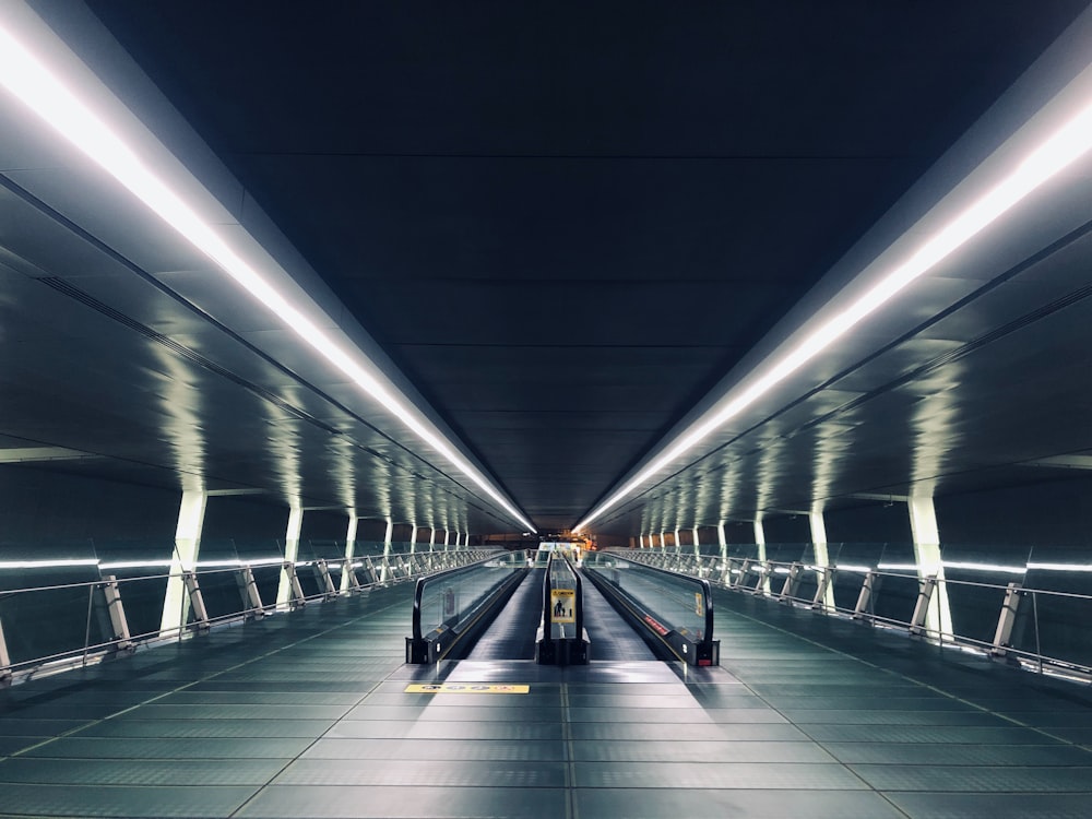 a subway station with a long walkway leading to the exit