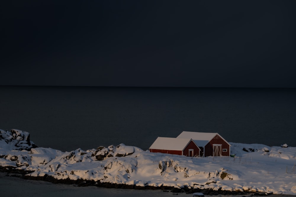 a red house sitting on top of snow covered ground