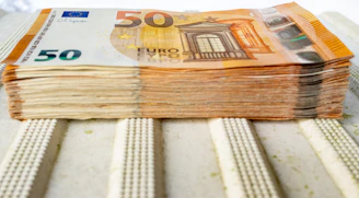 a stack of 50 euros bills sitting on top of a table
