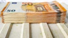 a stack of 50 euros bills sitting on top of a table