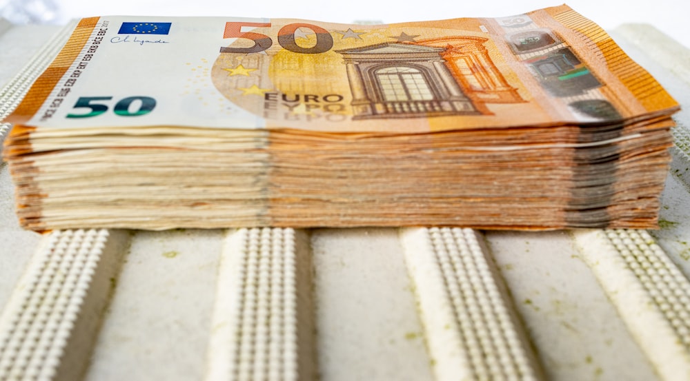 a stack of 50 euros bills sitting on top of a table