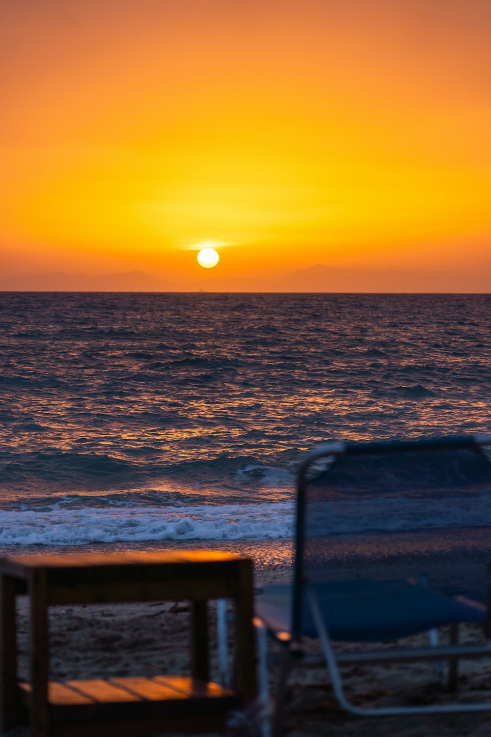 the sun is setting over the ocean on the beach