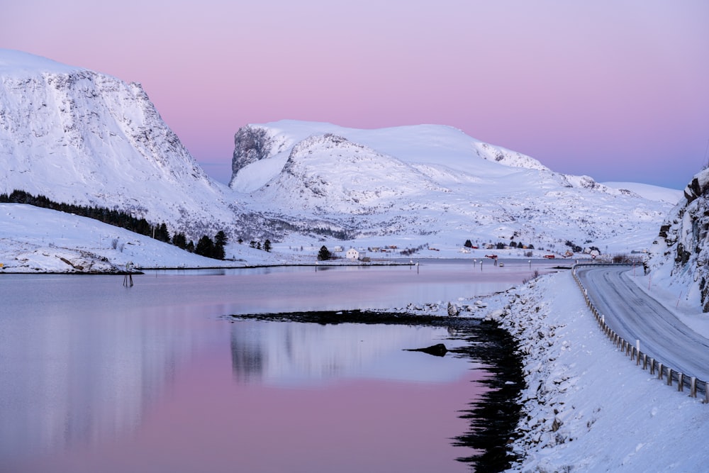 a snow covered mountain with a body of water in the foreground