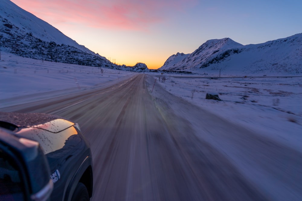 um carro dirigindo por uma estrada coberta de neve