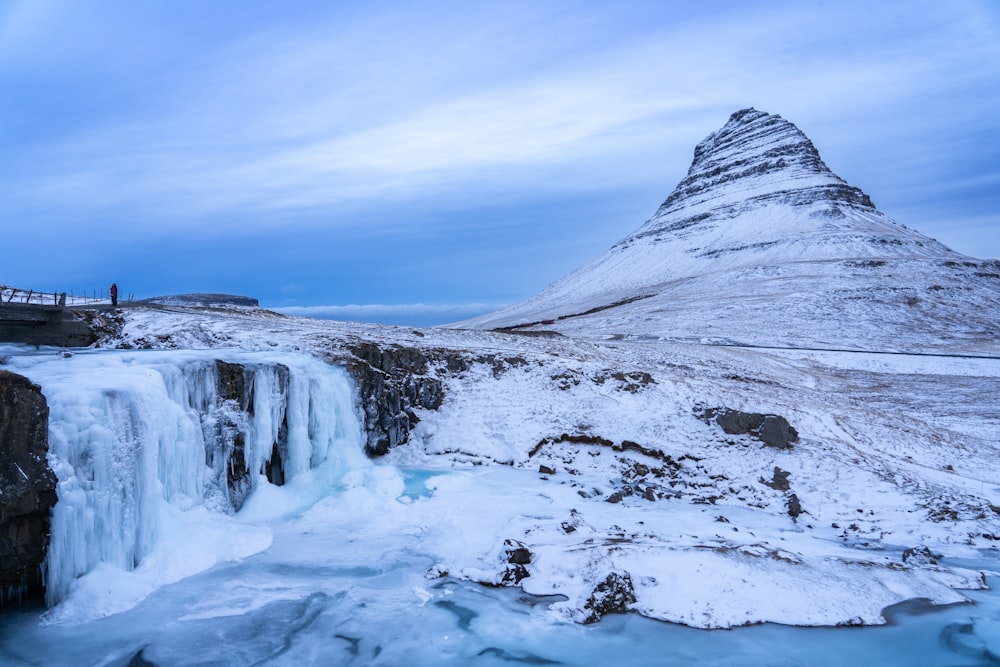 a frozen waterfall with a mountain in the background