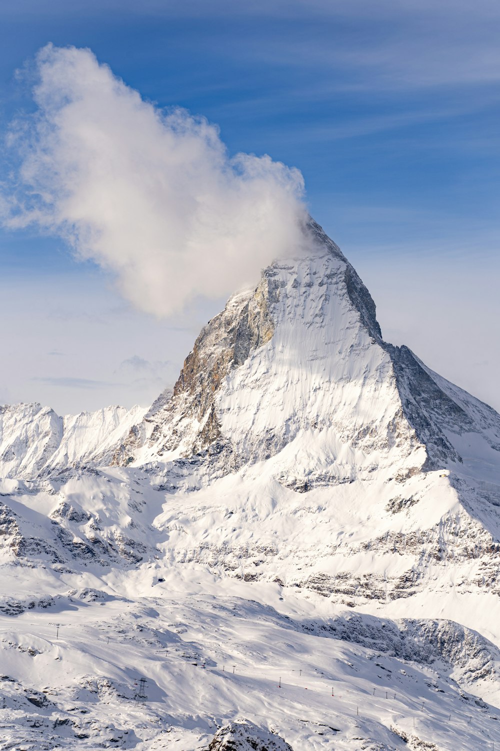 a mountain covered in snow under a blue sky