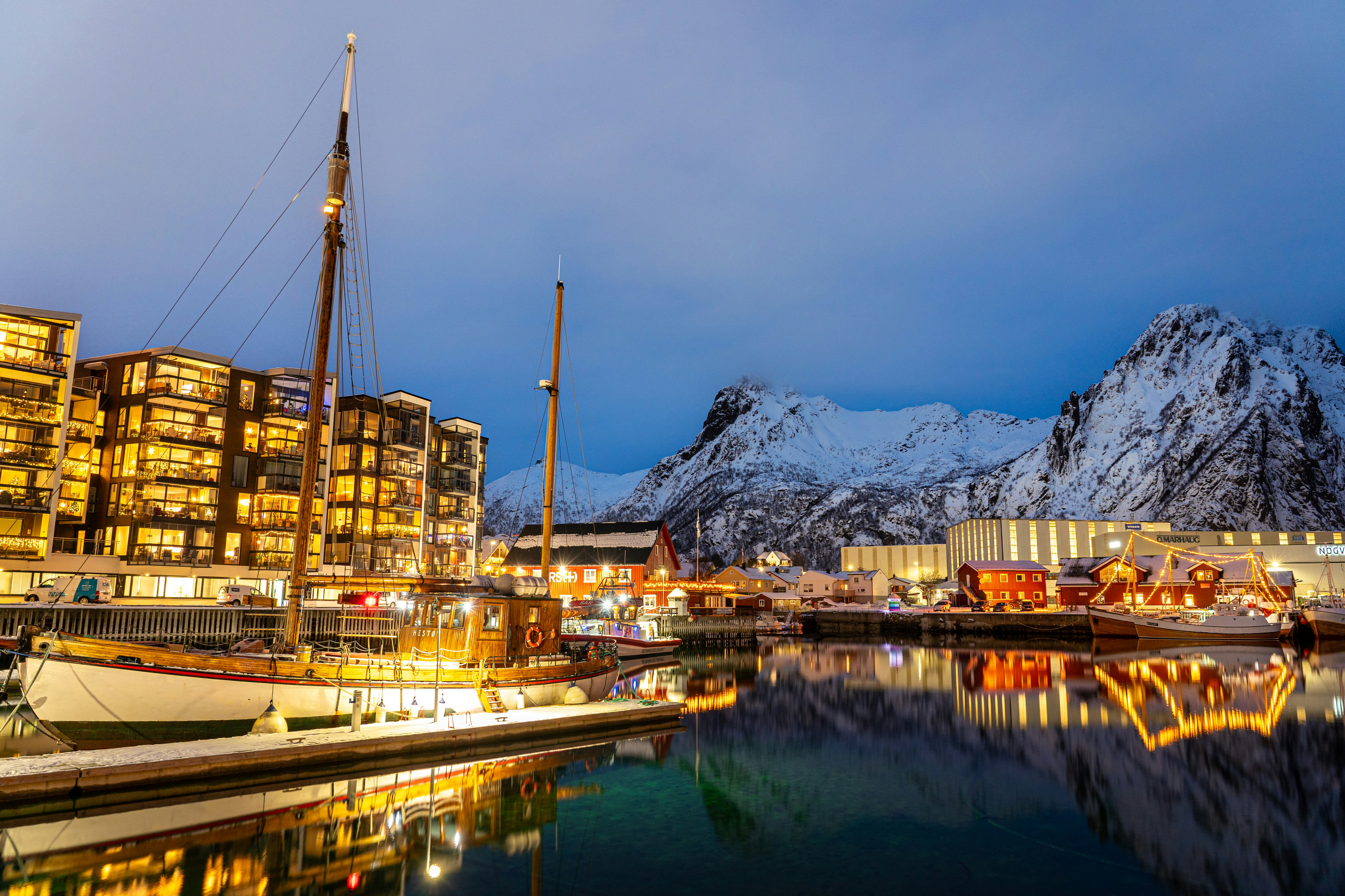 a boat docked in a harbor next to a mountain