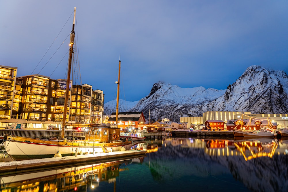 a boat docked in a harbor next to a mountain