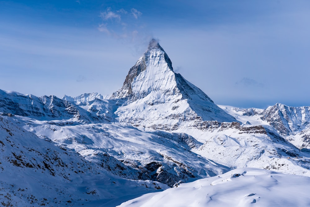 a snow covered mountain with a cloud in the sky